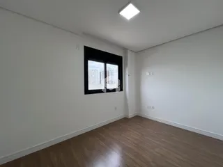 Sala de estar com piso de madeira e janela de grande porte.