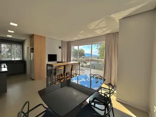 Sala de estar e jantar com vista para o exterior em um imóvel no Brasil.