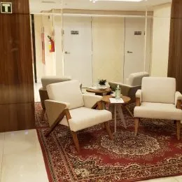 Sala de estar com poltronas e tapete em um imóvel residencial.