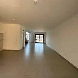 Corredor interno com paredes brancas e piso liso.