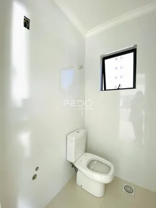 Foto de um banheiro interno com vaso sanitário branco e espelho.
