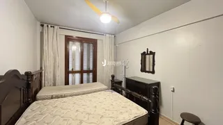 Quarto com cama de madeira e móveis de madeira.