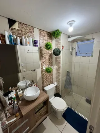 Foto de um banheiro interno com revestimento de cerâmica branca.
