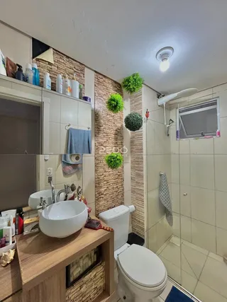 Foto de um banheiro com pias brancas e revestimento de parede em Lajeado.