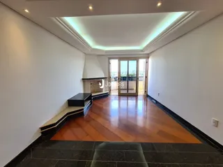 Corredor interno com piso de madeira e paredes brancas.