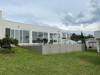 Fachada moderna de um imóvel em Lajeado, Brasil, com grandes janelas e área gramada.