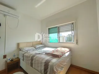 Quarto com cama de casal e janela.