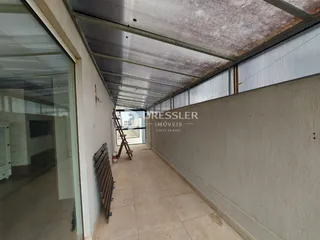 Foto de um corredor interno com piso de cerâmica e teto metálico.
