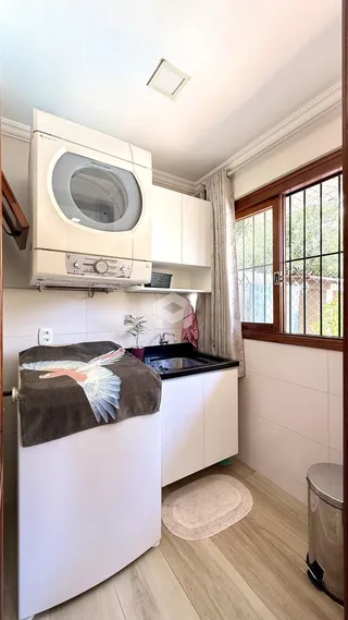 Foto de uma cozinha clara com armários brancos e piso de madeira.