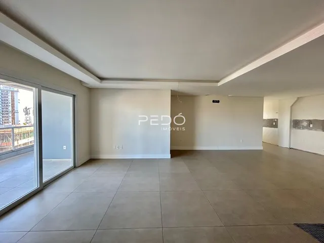 Ambiente interno de uma sala ampla com piso de cerâmica e porta de vidro.