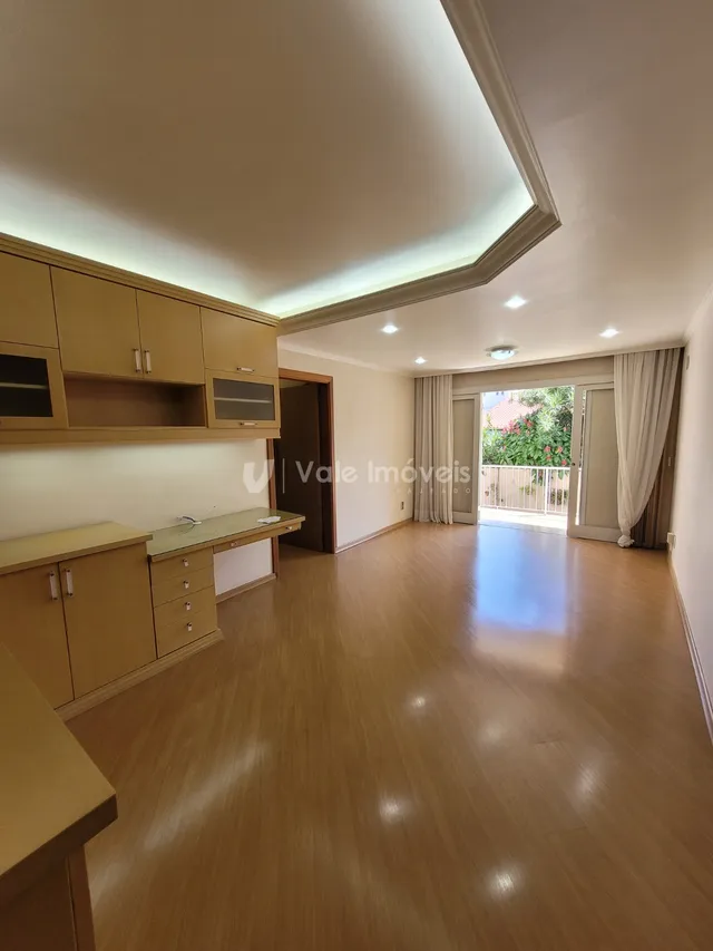 A sala de estar apresenta piso de madeira e armários de cozinha.