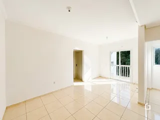 Interior de uma sala ampla com piso de cerâmica clara.