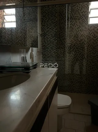 Foto de um banheiro com revestimento de azulejos e bancada clara.