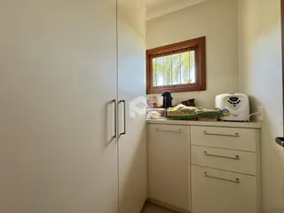 Interior de um ambiente com armário e móveis brancos.