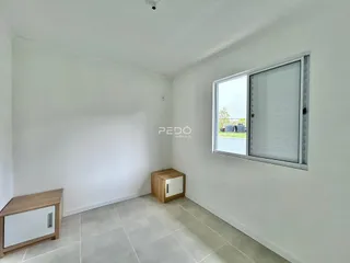 Ambiente interno de uma sala com paredes brancas e piso de cerâmica.