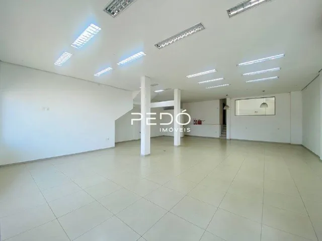 Espaço interno amplo com paredes brancas e teto claro.