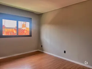 Foto de um ambiente interno com paredes cinzas e piso de madeira.