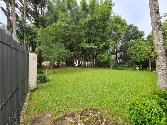 Vista de um gramado verde com árvores ao fundo