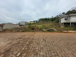 Vista da fachada de uma propriedade com área externa com vegetação alta.