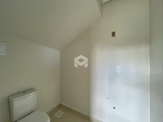 Vista interna de um banheiro com piso claro e paredes brancas.