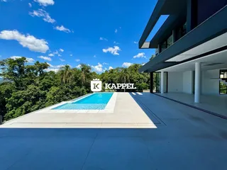 Vista externa mostrando uma piscina e paisagem verde exuberante.