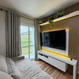 Sala de estar com painel de parede e televisão montada na parede.