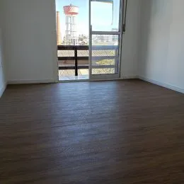 Foto do piso de madeira escura de um imóvel.