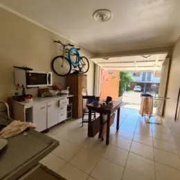 Foto de uma sala com piso de cerâmica e uma bicicleta apoiada na parede.