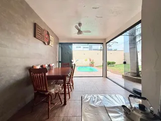 Interior de uma sala de jantar com vista para uma piscina externa.