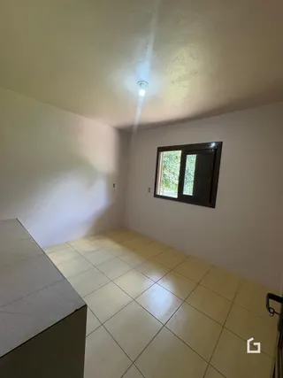 Interior de um cômodo com piso de cerâmica e janela.