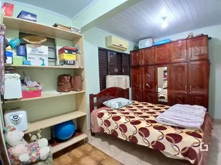 Quarto com armário de madeira e cama no interior de uma residência.