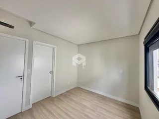 Hall de entrada com portas brancas e piso de madeira clara.