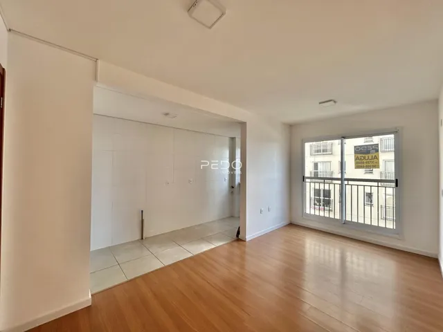 Sala de estar com piso de madeira clara e vista para a varanda.
