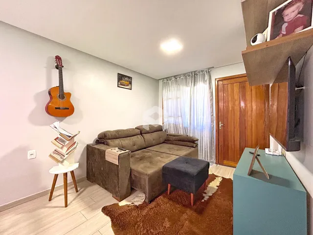 Sala de estar com sofá e piso de madeira em um imóvel no Brasil.