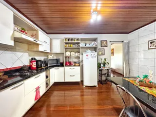 Foto de uma cozinha com armários brancos e piso de madeira em Lajeado.