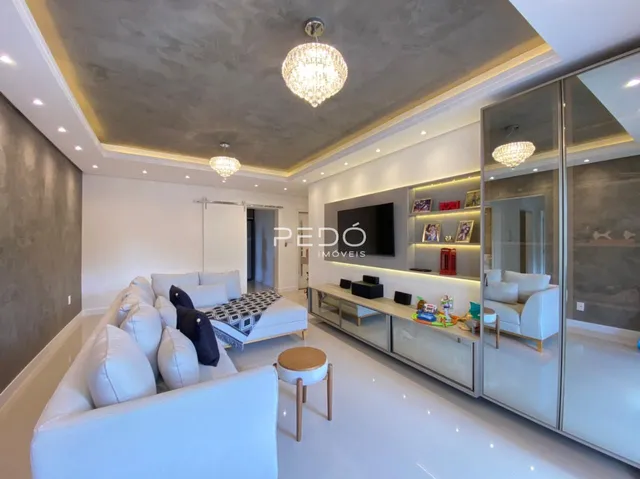 Sala de estar moderna com sofá branco e decoração elegante.