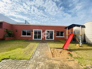 Fachada de uma residência com jardim e área de lazer.