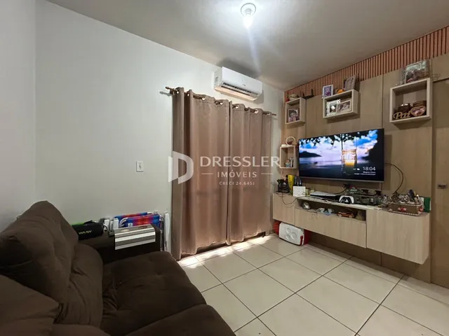 Sala de estar com sofá e cortinas em um imóvel no Brasil.