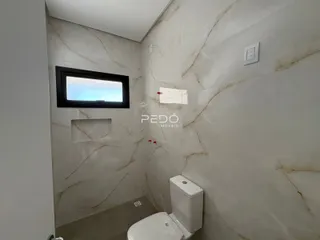 Banheiro com paredes revestidas em mármore claro.