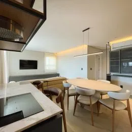 Sala de jantar com mesa e cadeiras em um ambiente claro.