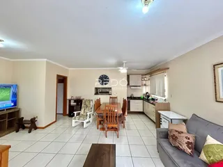 Ambiente interno de sala de jantar e cozinha com piso de cerâmica.