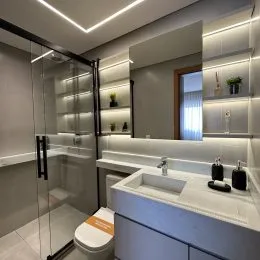 Banheiro com box de vidro e bancada moderna.