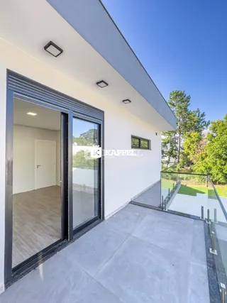 Fachada moderna de uma residência com porta de vidro e área externa.