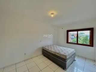 Quarto com piso de cerâmica e cama no interior de uma residência.