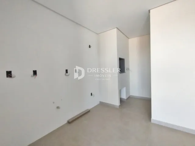 Vista interna de um corredor branco em um imóvel.