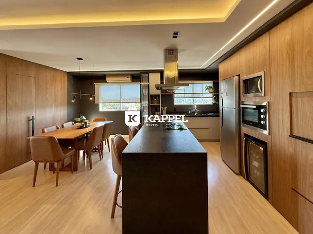 Vista de um ambiente de jantar integrado com cozinha moderna em um imóvel.