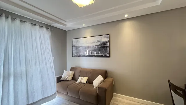 Sala de estar com sofá e decoração em parede cinza.
