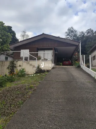 Fachada de uma residência com garagem e entrada de acesso.