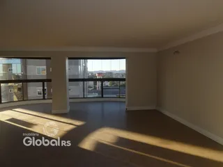 Interior de uma sala com grandes janelas que oferece uma vista da cidade.