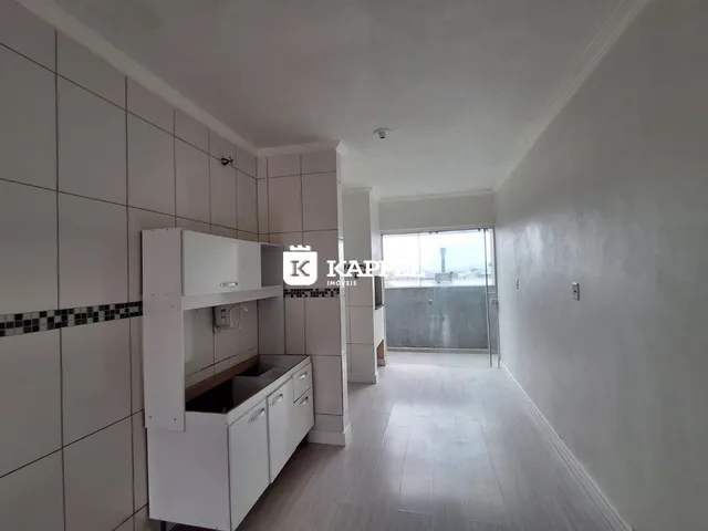 Foto de um corredor interno com armários brancos e piso claro.